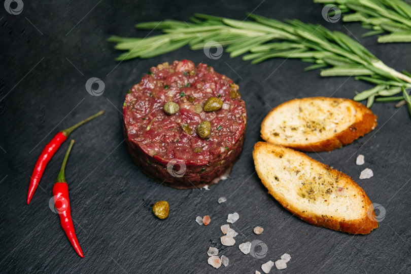 Скачать Тартар из сырой говядины с кростини и каперсами. фотосток Ozero