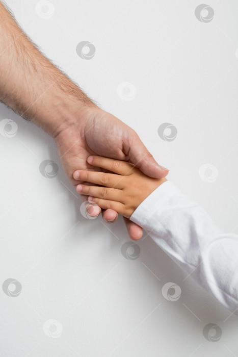 Скачать Взрослый белый мужчина и испаноязычный ребенок держатся за руки на белом фоне фотосток Ozero