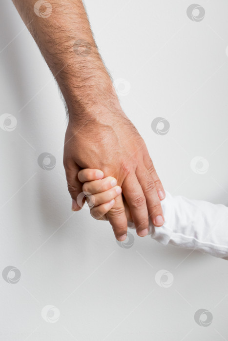 Скачать Взрослый и ребенок держатся за руки. Связь и доверие между поколениями фотосток Ozero