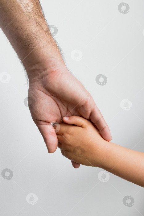 Скачать Взрослый и ребенок держатся за руки. Связь, поддержка, забота. Концепция дня отцов фотосток Ozero