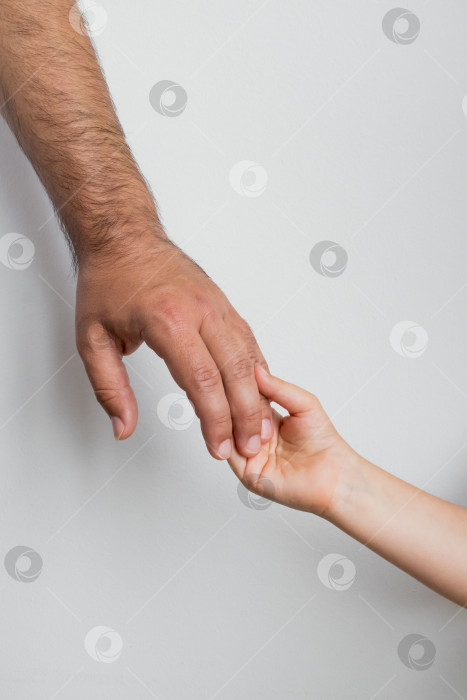 Скачать Взрослый мужчина держит ребенка за руку, символизируя доверие и связь фотосток Ozero