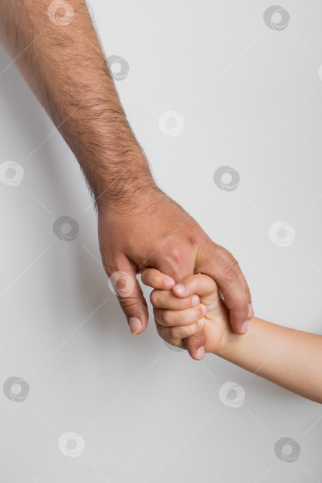 Скачать Рука взрослого, держащая руку ребенка, символизирует доверие и связь фотосток Ozero