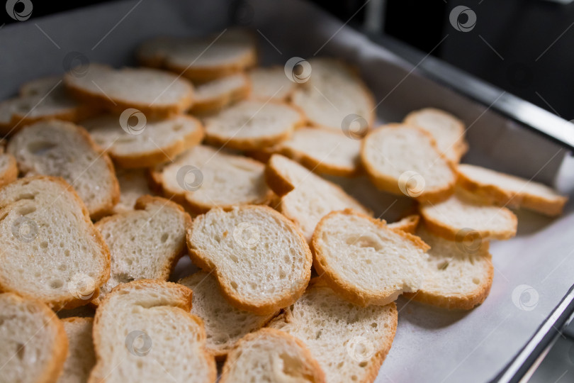 Скачать Горкой выложите нарезанный хлеб на противень для поджаривания фотосток Ozero