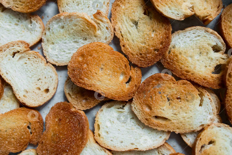 Скачать Крупный план золотистого хрустящего нарезанного ломтиками поджаренного хлеба на заднем плане фотосток Ozero