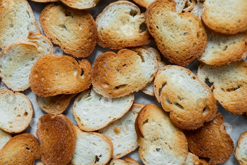 Скачать Золотисто-коричневые ломтики свежеиспеченного хлеба, уложенные внахлест на поверхность фотосток Ozero