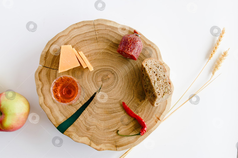 Скачать натюрморт с яблоками и другими продуктами, колосьями пшеницы на дубовой подставке и бокалом домашней крепкой настойки на кедровых орехах фотосток Ozero