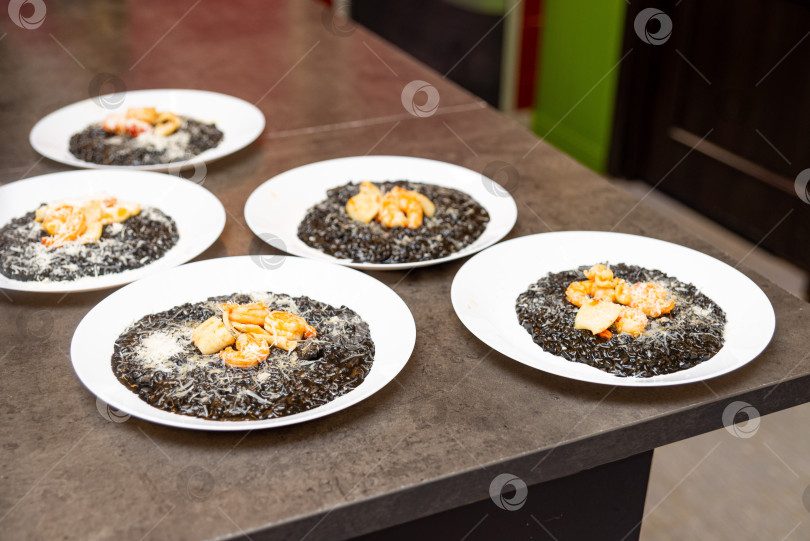 Скачать Ризотто в чернилах кальмара с гарниром из морепродуктов. фотосток Ozero