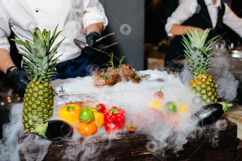 Скачать Шеф-повар подает копченое мясо с потрясающим эффектом сухого льда. фотосток Ozero