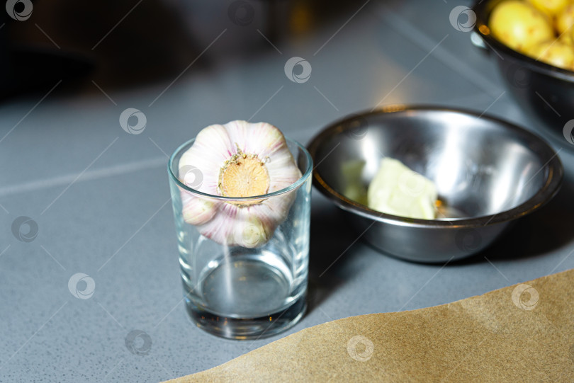 Скачать Целая луковица чеснока в стакане на кухонном столе. фотосток Ozero