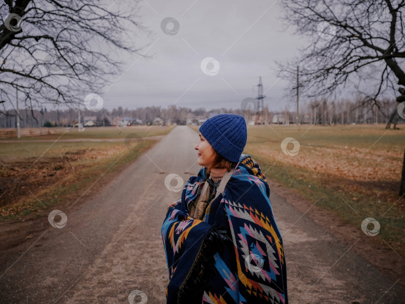 Скачать Взрослая пятидесятилетняя женщина осенью выезжает на природу недалеко от сельской местности. фотосток Ozero
