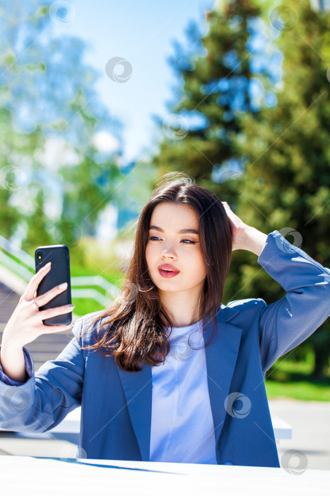 Скачать Молодая красивая женщина фотографирует себя на смартфон фотосток Ozero