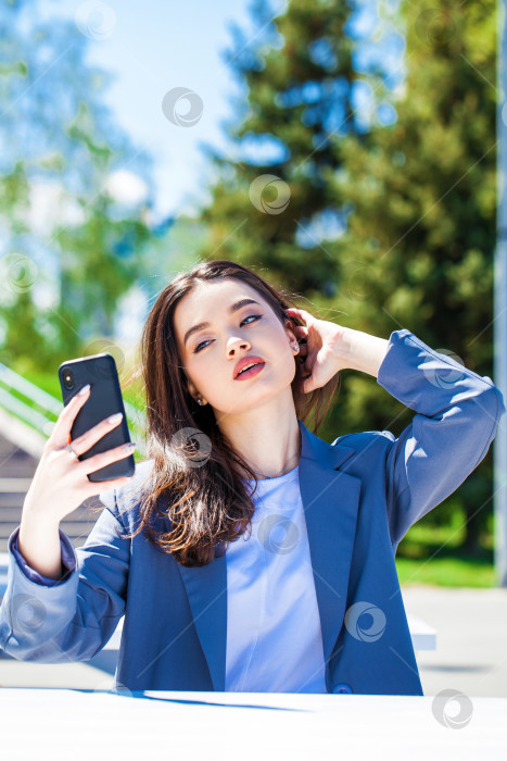 Скачать Молодая красивая женщина фотографирует себя на смартфон фотосток Ozero