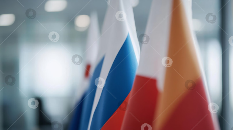 Скачать Множество национальных флагов, представляющих международную дипломатию, на размытом фоне офиса во время официальной встречи фотосток Ozero