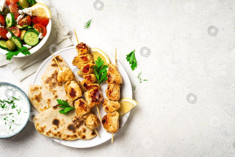 Скачать Сувлаки с курицей на шпажках, лепешками и греческим салатом фотосток Ozero