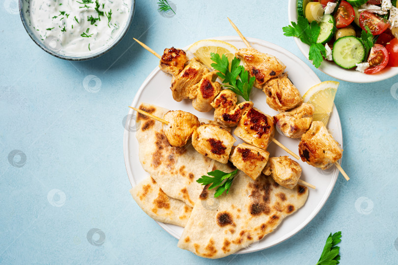 Скачать Сувлаки с курицей на шпажках, лепешками из лаваша и греческим салатом фотосток Ozero