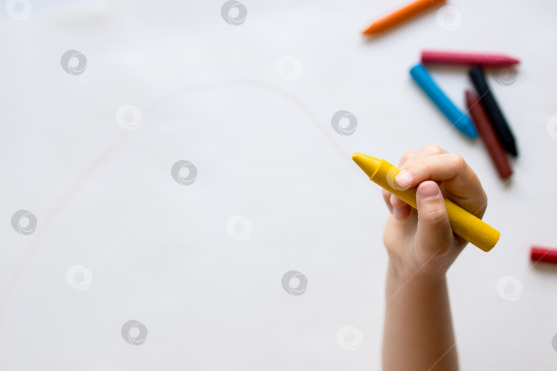 Скачать Ребенок рисует мелками на белой бумаге фотосток Ozero