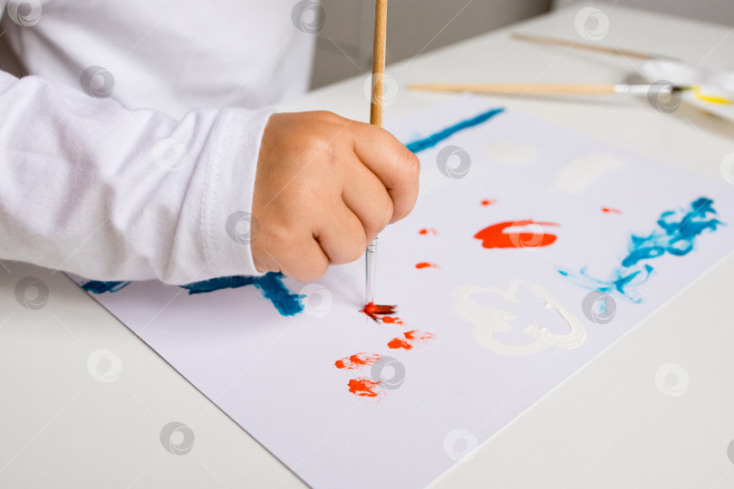 Скачать Детское рисование акварелью на белой бумаге во время творческой арт-сессии фотосток Ozero