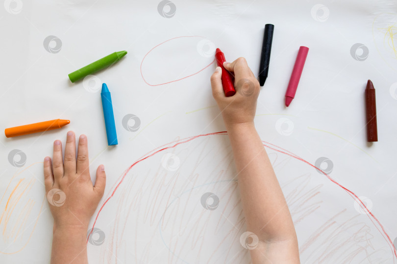 Скачать Ребенок рисует разноцветными мелками на бумаге фотосток Ozero