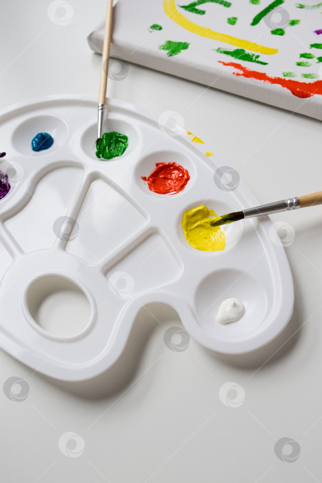 Скачать Красочная смесь красок на палитре художника с кистями и холстом фотосток Ozero