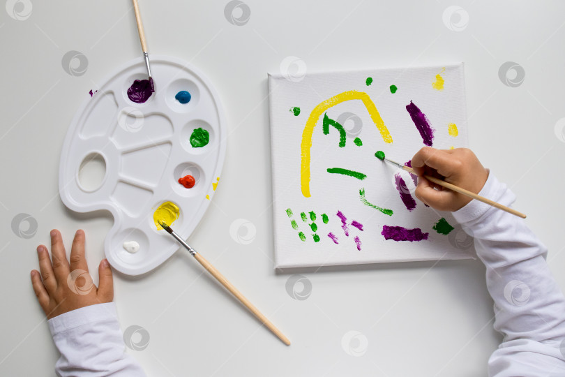 Скачать Детская живопись на холсте с помощью красочной палитры и кистей фотосток Ozero