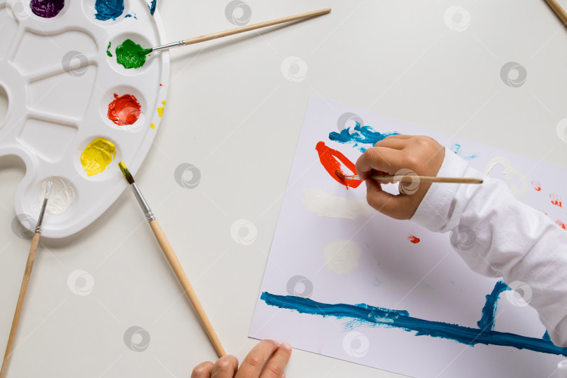 Скачать Детское рисование акварелью на белой бумаге с помощью цветовой палитры и кистей фотосток Ozero