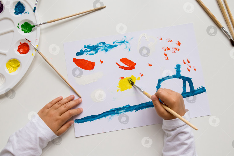 Скачать Детское красочное рисование кистями и палитрой на белой поверхности фотосток Ozero