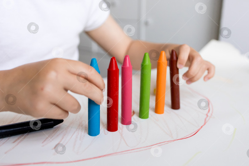 Скачать Ребенок рисует разноцветными мелками на бумаге фотосток Ozero
