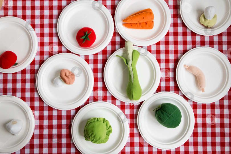 Скачать Шикарные овощи на белых тарелках на красной клетчатой скатерти фотосток Ozero