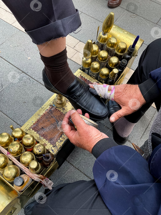Скачать Услуга по чистке обуви от зрелого мужчины на городской улице с латунным набором фотосток Ozero