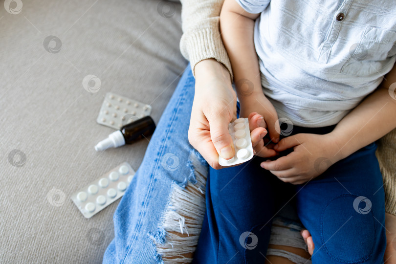 Скачать Мать и ребенок с блистерной упаковкой лекарств на диване фотосток Ozero