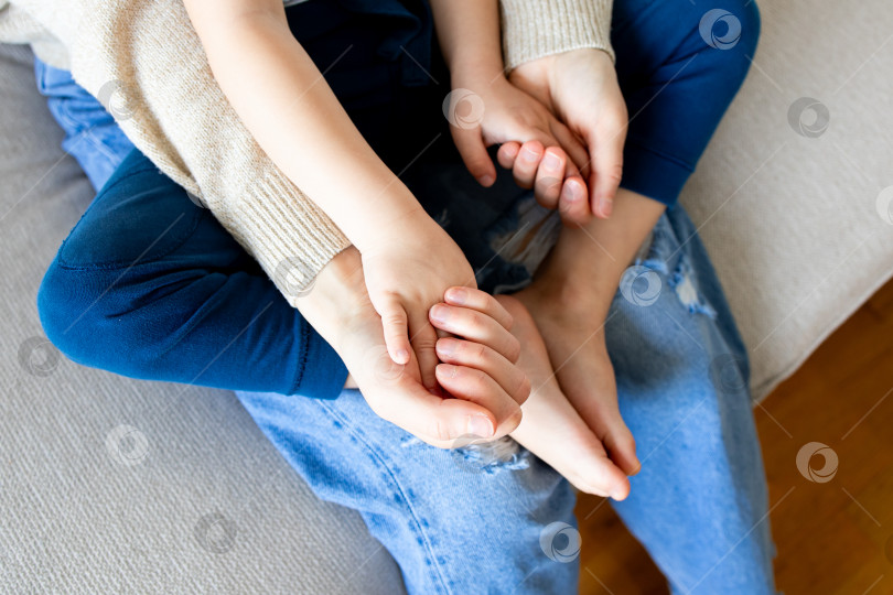 Скачать Крупным планом кавказский ребенок и взрослый обнимаются в утешающем жесте на диване фотосток Ozero