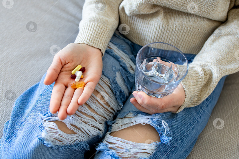 Скачать Молодой кавказец, принимающий витамины и воду в непринужденной домашней обстановке фотосток Ozero