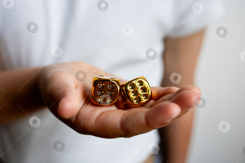 Скачать Рука, держащая золотые игральные кости крупным планом фотосток Ozero