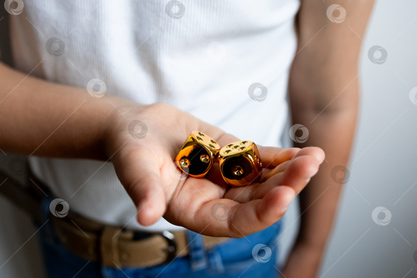 Скачать Молодая испаноязычная женщина держит в руке золотые игральные кости фотосток Ozero