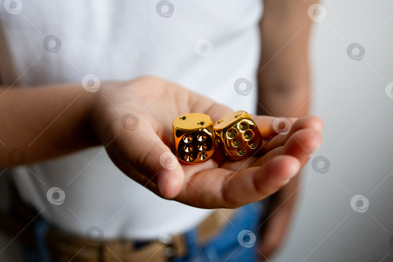Скачать Крупным планом молодая испаноязычная женщина с двумя золотыми игральными костями в руках фотосток Ozero