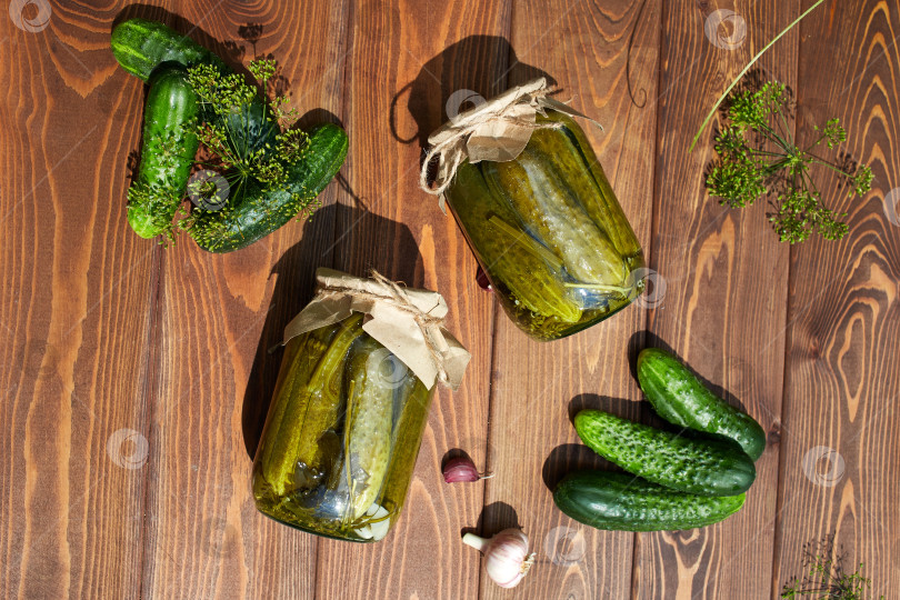 Скачать Маринованные огурцы в банках, свежие огурцы на деревянном столе. Домашнее консервирование. фотосток Ozero