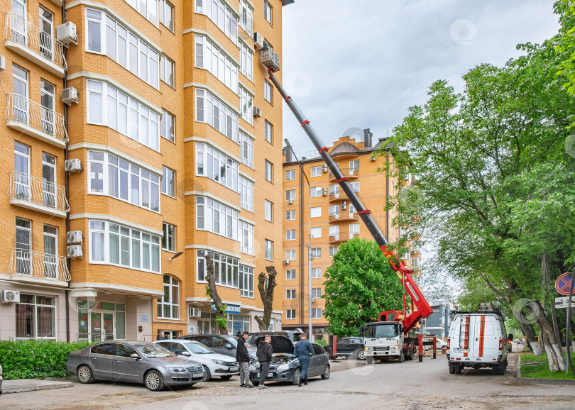Скачать Работа подъёмного крана возле жилого дома. Установка кондиционера в многоэтажке фотосток Ozero