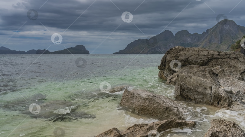 Скачать Прибрежные скалы омываются волнами бирюзового океана. фотосток Ozero
