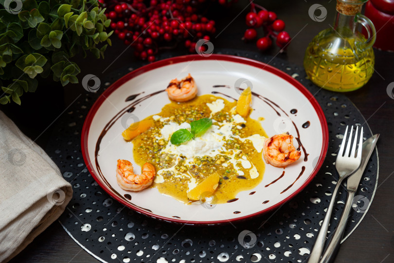 Скачать Изысканное блюдо из креветок с бурратой и фисташковым соусом. фотосток Ozero