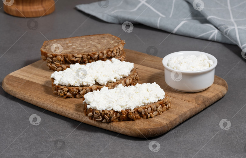 Скачать Вкусный ржаной хлеб с творожной начинкой на деревянной доске в современной кухонной обстановке фотосток Ozero