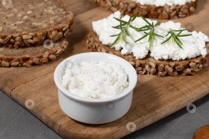 Скачать Вкусный ржаной хлеб со сливочным сыром и свежей зеленью на деревянной доске в деревенском стиле фотосток Ozero