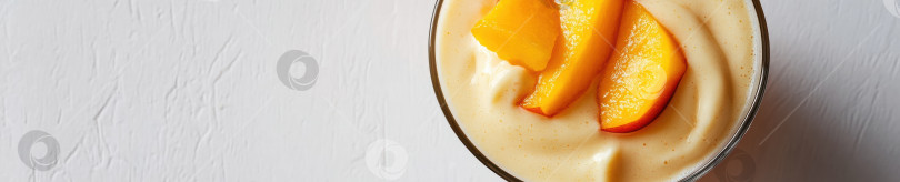 Скачать Сливочно-персиковый смузи в прозрачном бокале с кусочками свежего персика - концепция освежающего напитка фотосток Ozero