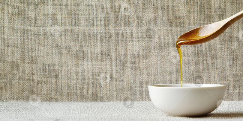 Скачать Золотистая капелька рапсового масла, падающая в белую чашу. Концепция с крупным планом на кулинарную и натуральную тематику фотосток Ozero