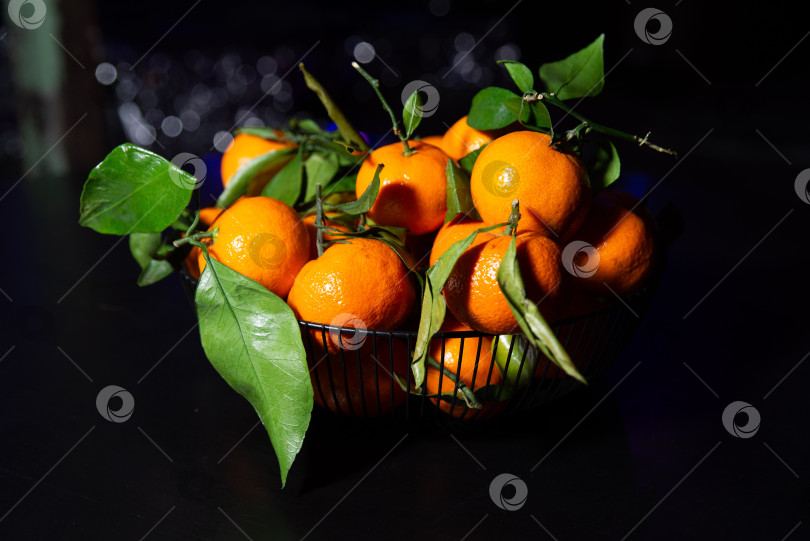 Скачать Свежие мандарины в корзинке с листьями. фотосток Ozero