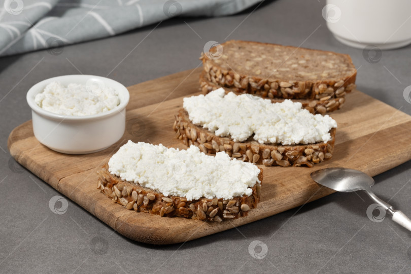 Скачать Вкусный ржаной хлеб с творожной начинкой на деревянной доске в современной кухонной обстановке фотосток Ozero