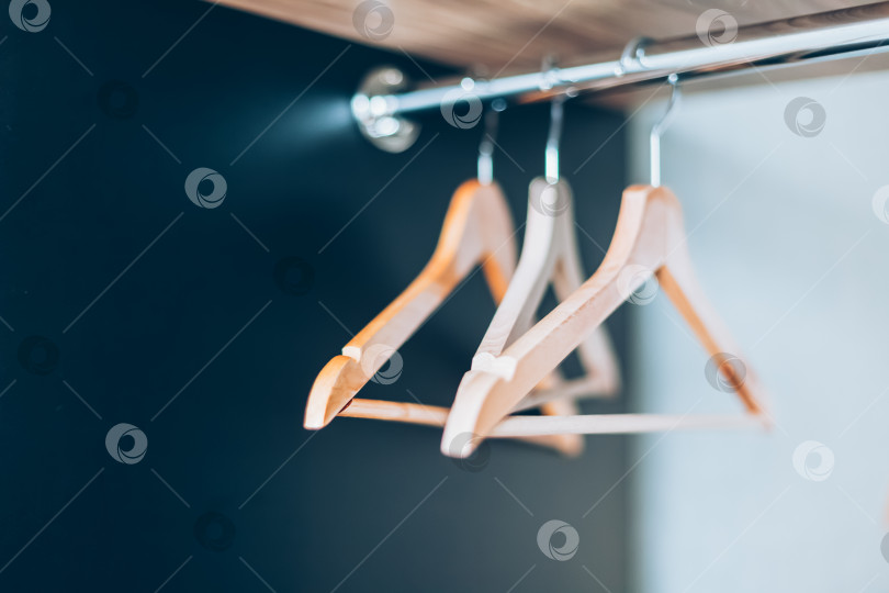 Скачать Пустые деревянные вешалки на перекладине в шкафу фотосток Ozero