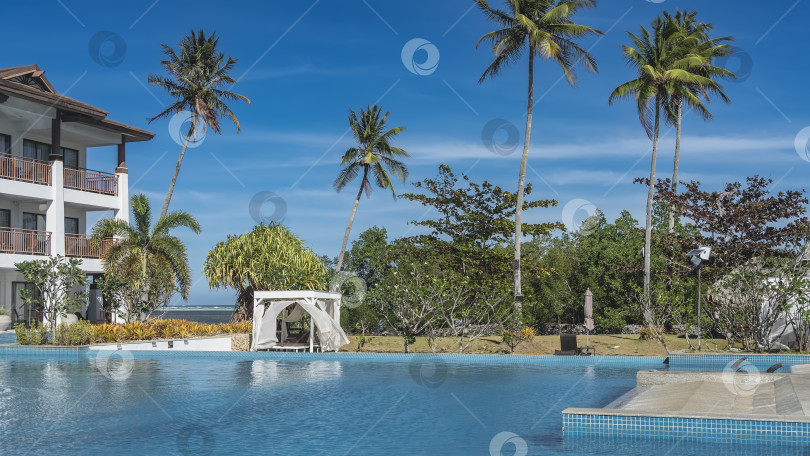 Скачать Бассейн Blue resort. Шезлонги под навесом, занавески развеваются на ветру. фотосток Ozero