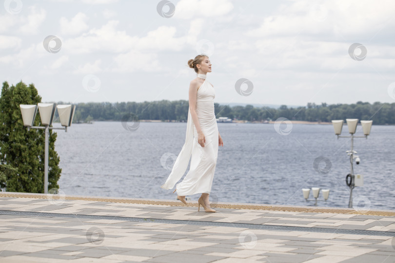 Скачать Молодая красивая женщина в длинном белом платье фотосток Ozero