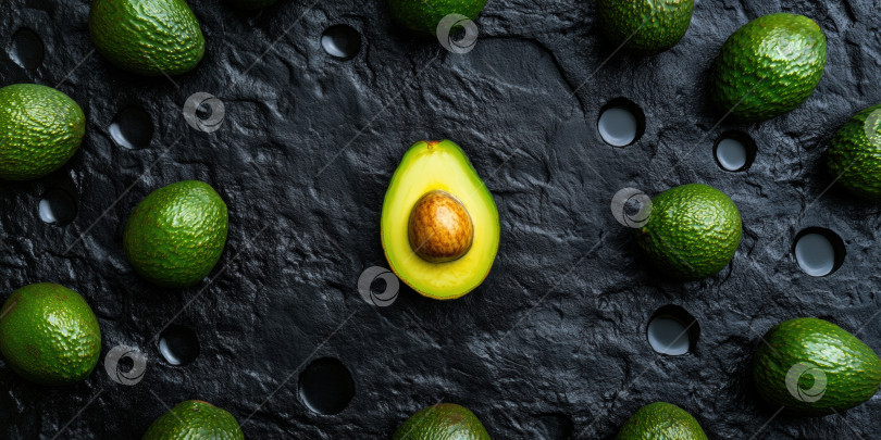 Скачать Свежие авокадо, выложенные ровным слоем на черном грифельном фоне, для кулинарного и фуд-дизайна фотосток Ozero
