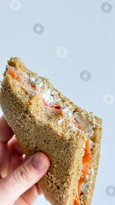 Скачать Ручной сэндвич с лососем и сливочным сыром с цельнозерновым хлебом фотосток Ozero